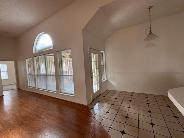 2414 W Stillwater Dr, Mesquite, TX 75181 - interior space featuring healthy amount of natural light, a textured ceiling, vaulted ceiling, and light wood-style floors