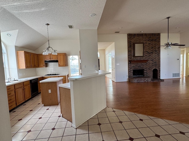2414 W Stillwater Dr, Mesquite, TX 75181 - kitchen featuring black dishwasher, open floor plan, light countertops, a textured ceiling, and under cabinet range hood