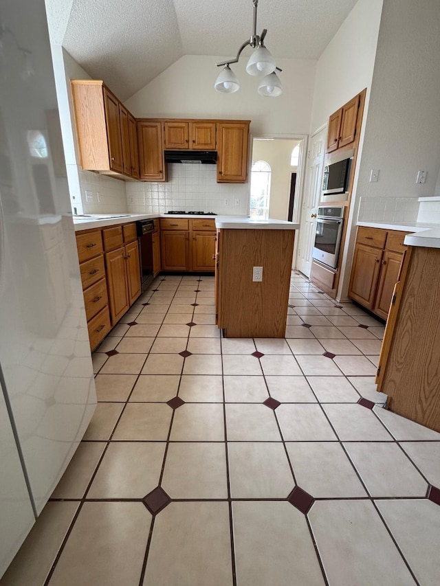 2414 W Stillwater Dr, Mesquite, TX 75181 - kitchen featuring stainless steel appliances, vaulted ceiling, under cabinet range hood, light countertops, and tasteful backsplash