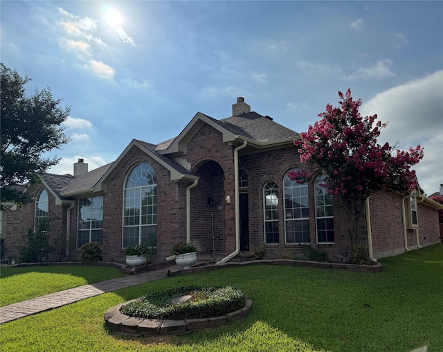 2414 W Stillwater Dr, Mesquite, TX 75181 - view of front of house featuring brick siding, a chimney, and a front lawn