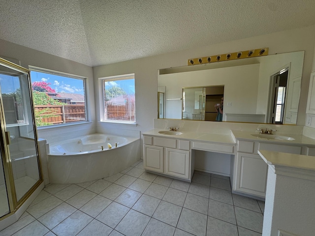 2414 W Stillwater Dr, Mesquite, TX 75181 - bathroom featuring a textured ceiling, double vanity, a jetted tub, a stall shower, and tile patterned flooring