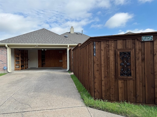 2414 W Stillwater Dr, Mesquite, TX 75181 - view of side of property with roof with shingles, concrete driveway, and a garage