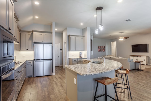 kitchen featuring appliances with stainless steel finishes, gray cabinets, sink, and hanging light fixtures