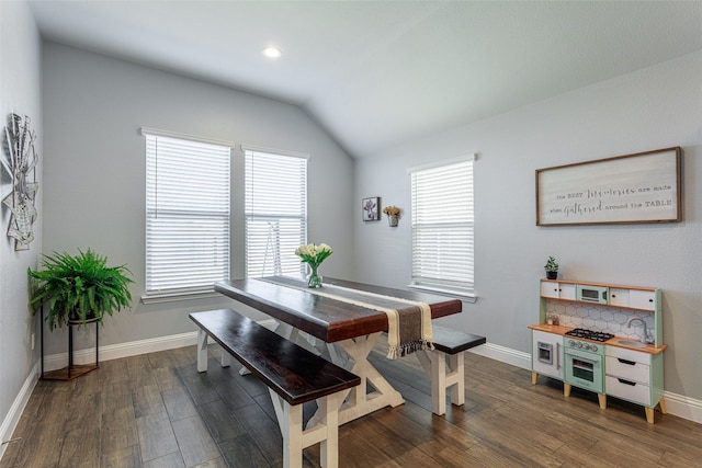 dining space with dark wood-type flooring and vaulted ceiling