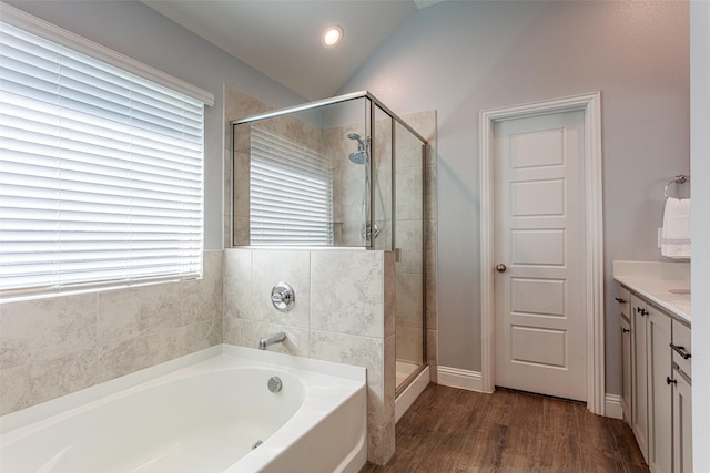 bathroom with vanity, hardwood / wood-style flooring, vaulted ceiling, and independent shower and bath