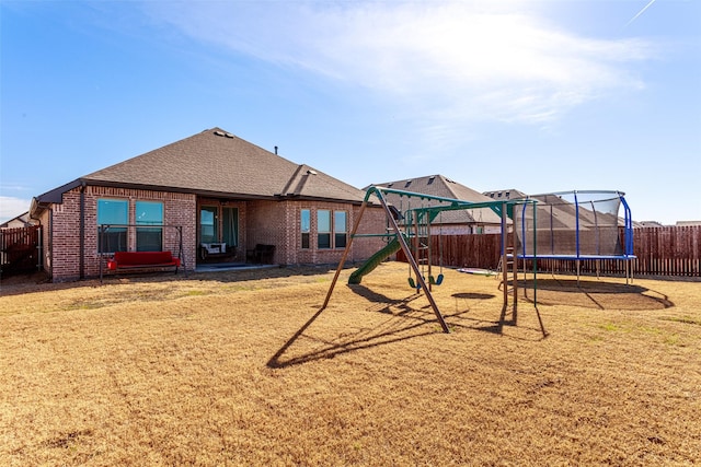 view of jungle gym with a trampoline and a lawn