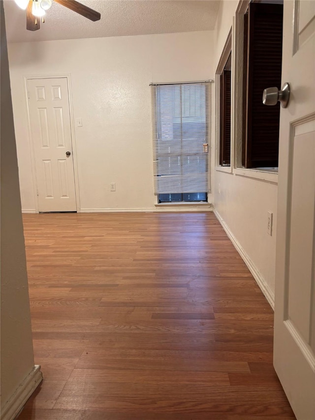 empty room featuring ceiling fan, hardwood / wood-style floors, and a textured ceiling