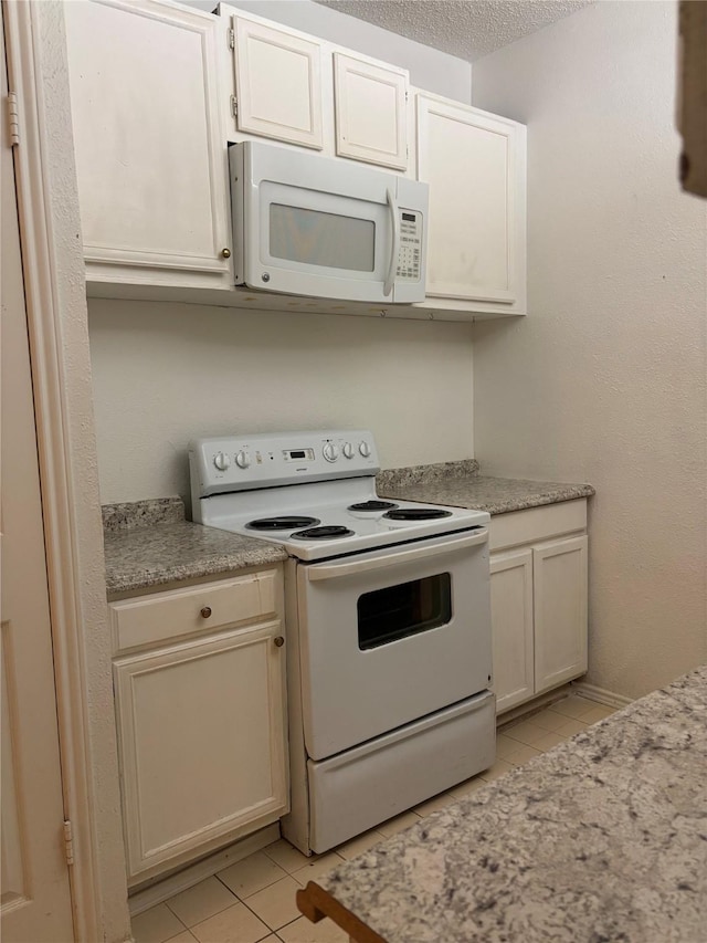 kitchen featuring white cabinetry, white appliances, a textured ceiling, and light tile patterned flooring