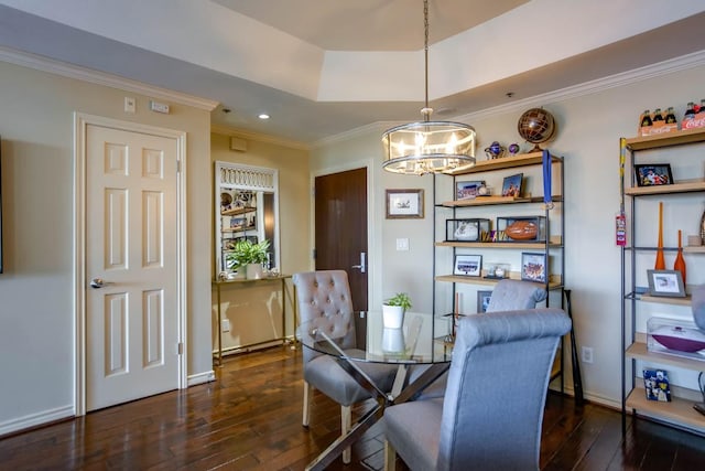 dining area featuring dark wood-type flooring, ornamental molding, a tray ceiling, and a notable chandelier