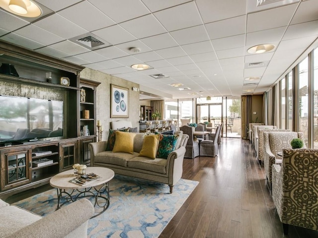 living room with dark hardwood / wood-style flooring, a paneled ceiling, and floor to ceiling windows