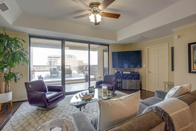 living room featuring ornamental molding, a tray ceiling, and hardwood / wood-style floors