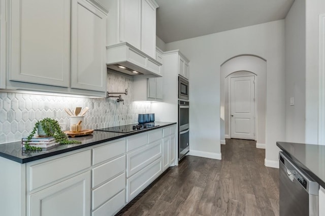 kitchen with dark hardwood / wood-style flooring, decorative backsplash, white cabinets, and appliances with stainless steel finishes