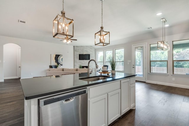 kitchen featuring sink, white cabinetry, decorative light fixtures, dishwasher, and an island with sink