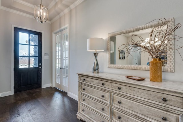 foyer featuring dark hardwood / wood-style flooring, crown molding, a raised ceiling, and an inviting chandelier