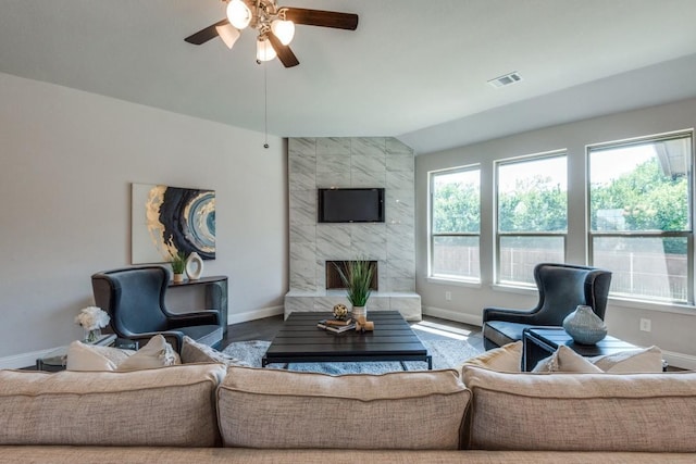 living room with vaulted ceiling, a wealth of natural light, and ceiling fan