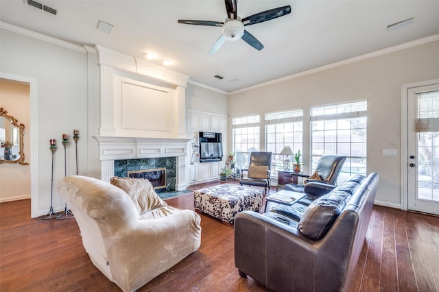 living room with crown molding, a wealth of natural light, and a fireplace