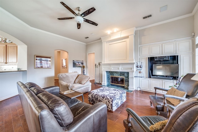 living room featuring a fireplace, ornamental molding, dark hardwood / wood-style floors, and ceiling fan