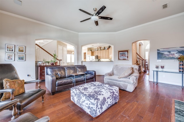 living room featuring dark wood-type flooring, ornamental molding, and ceiling fan