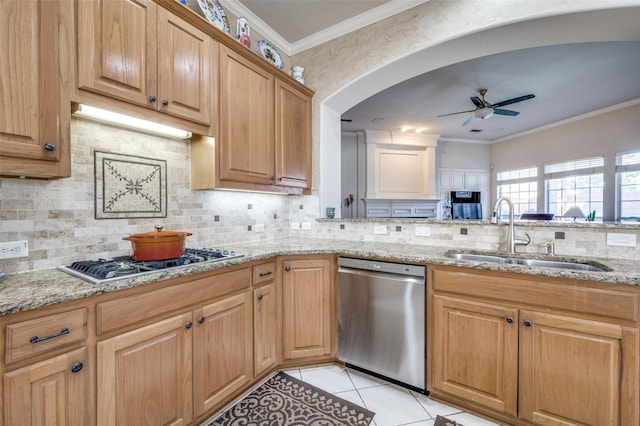 kitchen featuring light stone countertops, crown molding, appliances with stainless steel finishes, and sink