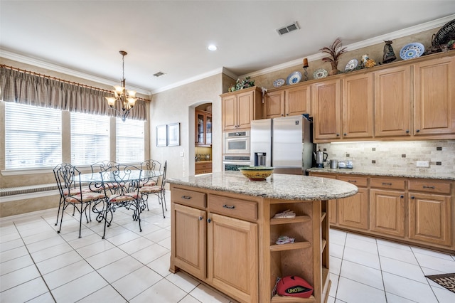 kitchen with light stone countertops, stainless steel appliances, a center island, and hanging light fixtures