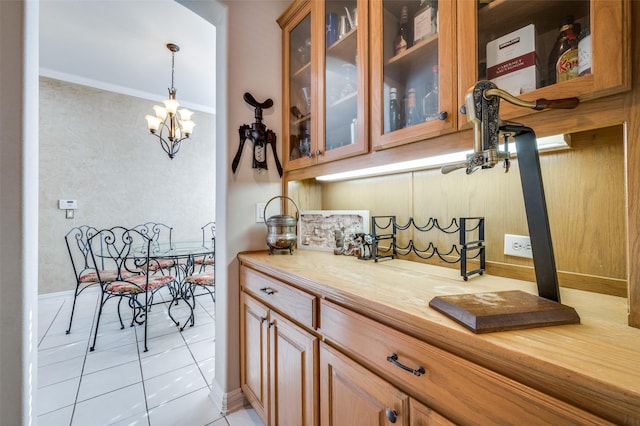 kitchen featuring hanging light fixtures, crown molding, light tile patterned floors, and an inviting chandelier