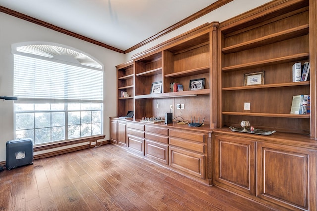 home office with crown molding, built in desk, a wealth of natural light, and light hardwood / wood-style floors