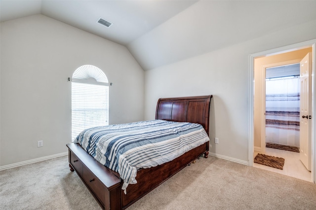 bedroom featuring lofted ceiling and light carpet