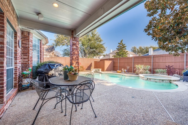 view of pool featuring an in ground hot tub, a grill, and a patio