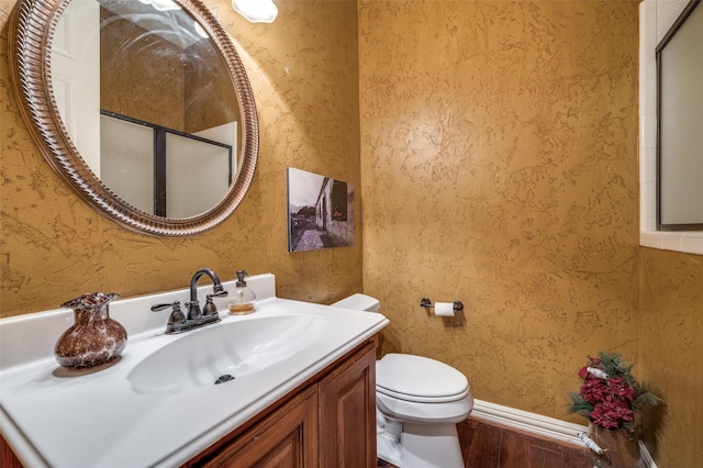 bathroom with vanity, wood-type flooring, and toilet