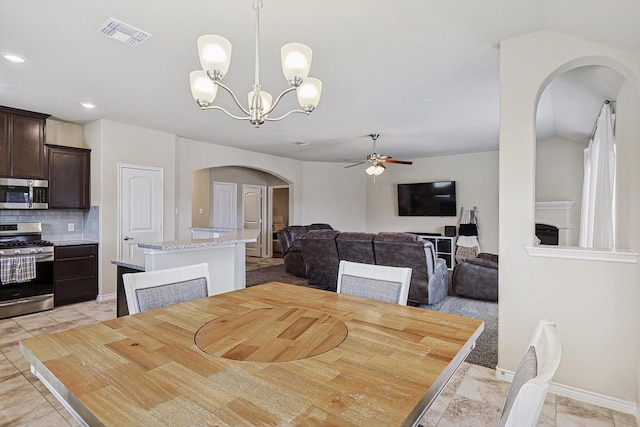 dining space featuring visible vents, arched walkways, baseboards, ceiling fan with notable chandelier, and recessed lighting