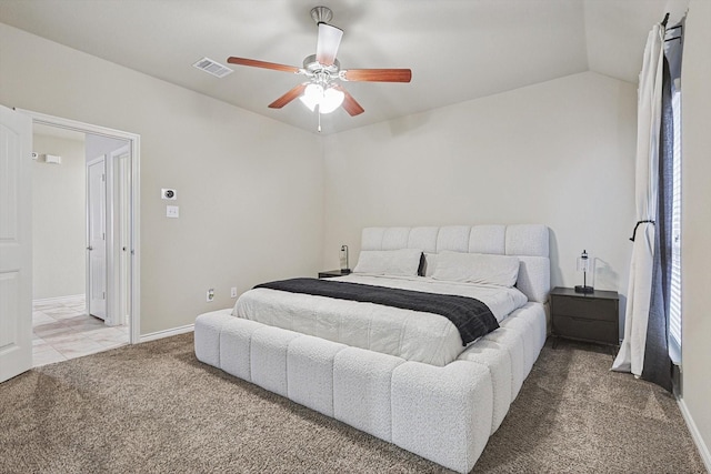 carpeted bedroom featuring lofted ceiling, visible vents, ceiling fan, and baseboards