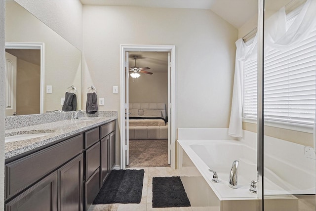 ensuite bathroom featuring double vanity, a bath, ensuite bath, vaulted ceiling, and a sink