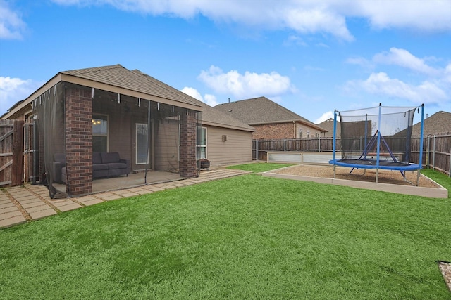 view of yard with a trampoline, a patio area, and a fenced backyard