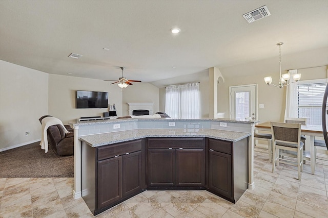 kitchen with open floor plan, dark brown cabinetry, visible vents, and pendant lighting