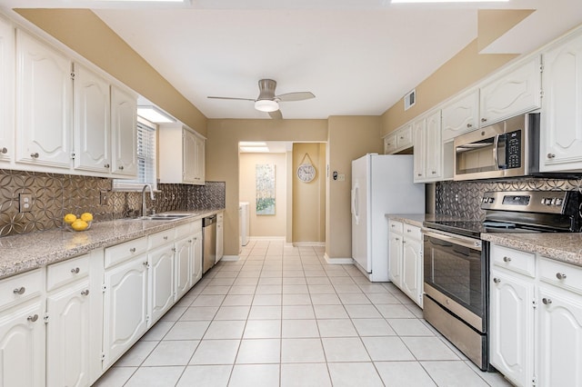 kitchen with light tile patterned flooring, stainless steel appliances, sink, and white cabinets