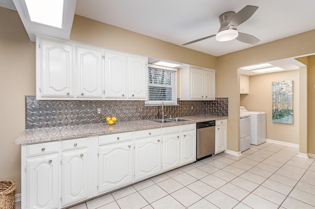 kitchen featuring washer and dryer, sink, white cabinets, backsplash, and stainless steel dishwasher