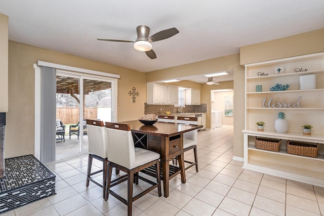 tiled dining space with ceiling fan and sink