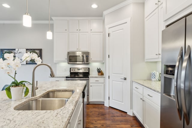 kitchen featuring sink, appliances with stainless steel finishes, white cabinetry, hanging light fixtures, and light stone countertops