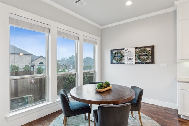 dining space featuring dark hardwood / wood-style flooring and ornamental molding