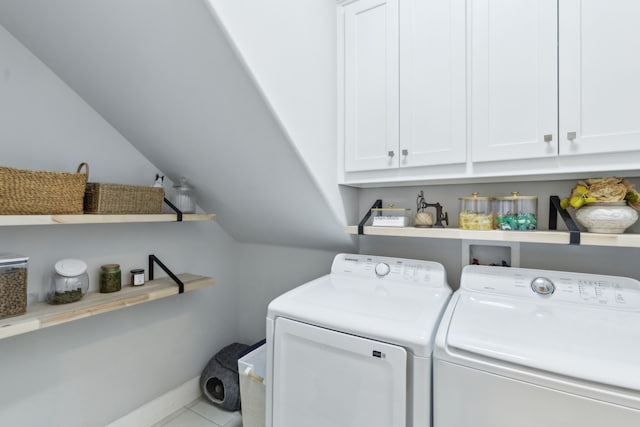 clothes washing area featuring washing machine and dryer and cabinets