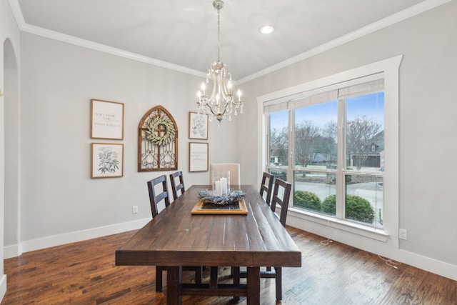 dining room featuring crown molding, dark wood-type flooring, and a notable chandelier