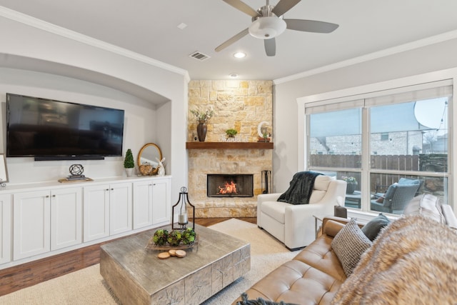 living room with crown molding, ceiling fan, a fireplace, and light hardwood / wood-style flooring