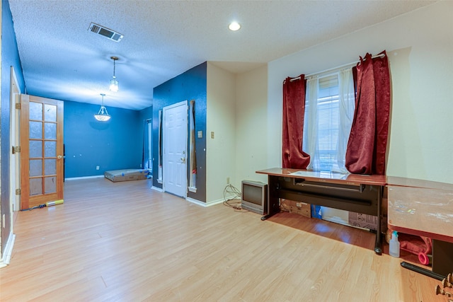 interior space featuring a textured ceiling and wood-type flooring