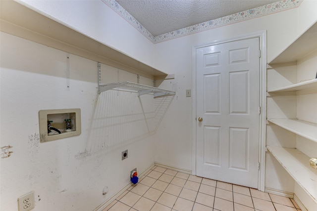 clothes washing area featuring a textured ceiling, hookup for an electric dryer, washer hookup, and light tile patterned floors