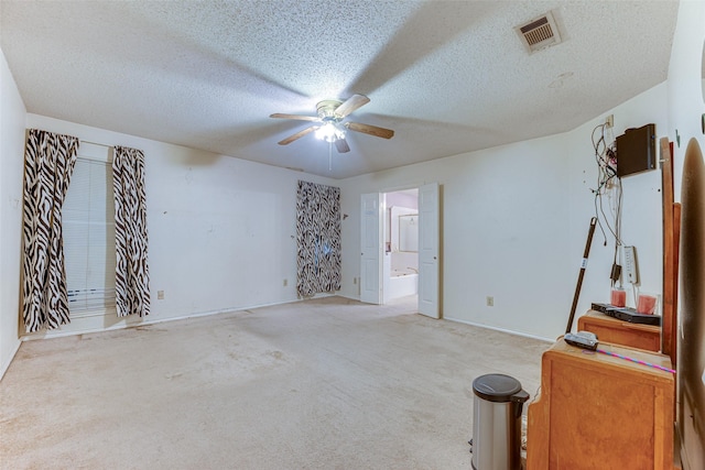 carpeted empty room featuring a textured ceiling and ceiling fan