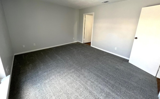 spare room with dark carpet