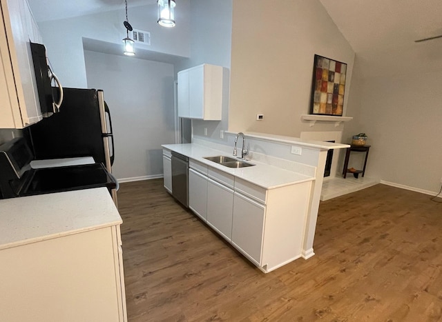 kitchen featuring lofted ceiling, sink, appliances with stainless steel finishes, hanging light fixtures, and white cabinets