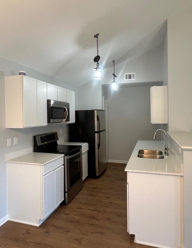 kitchen featuring stainless steel appliances, sink, white cabinets, and decorative light fixtures