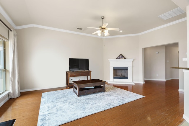 living room with hardwood / wood-style floors, ornamental molding, and ceiling fan