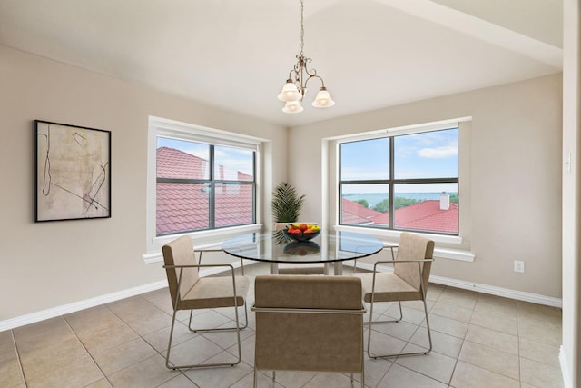 dining space with a notable chandelier, light tile patterned flooring, and baseboards